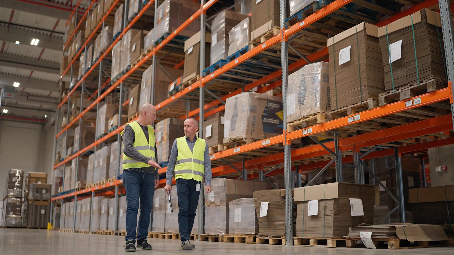 Mihai Radu, Plant Manager at THIMM Sibiu, walking with a colleague through the warehouse racks