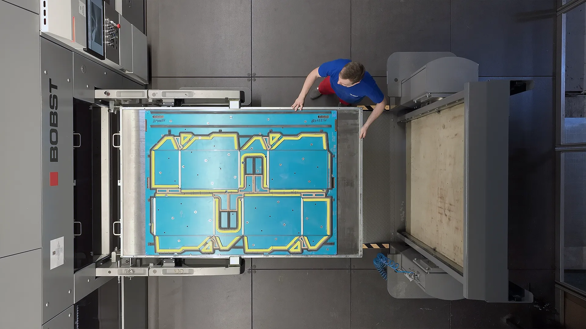 Top-down shot of an operator loading a cutting die into the BOBST MASTERCUT