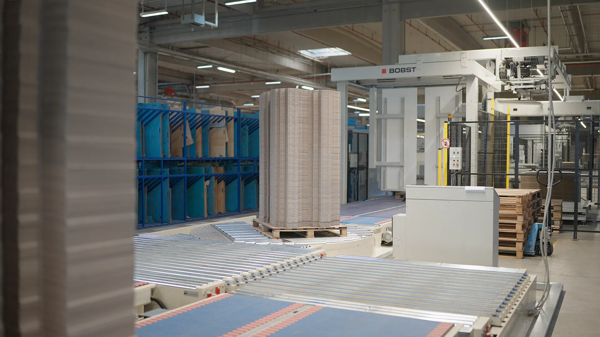 Pallet of corrugated die-cut blanks and BOBST palletizer at the end of the line